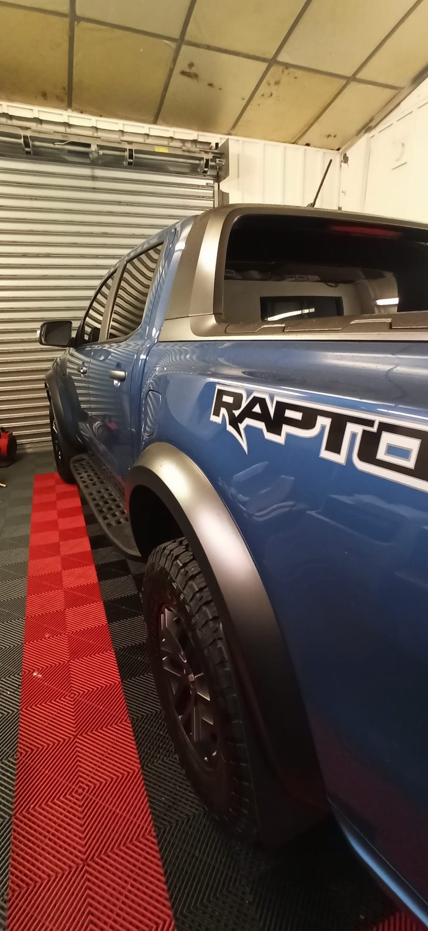 Ford Ranger Raptor bleu avec vitres teintées dans l'atelier