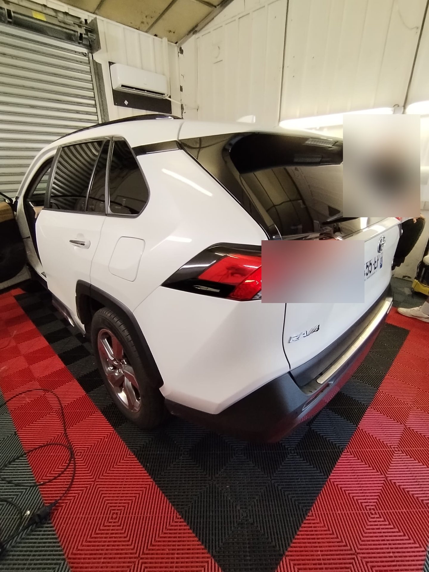 Pose de film teinté en cours sur un Toyota RAV4 blanc par un poseur TeinteDeVitres